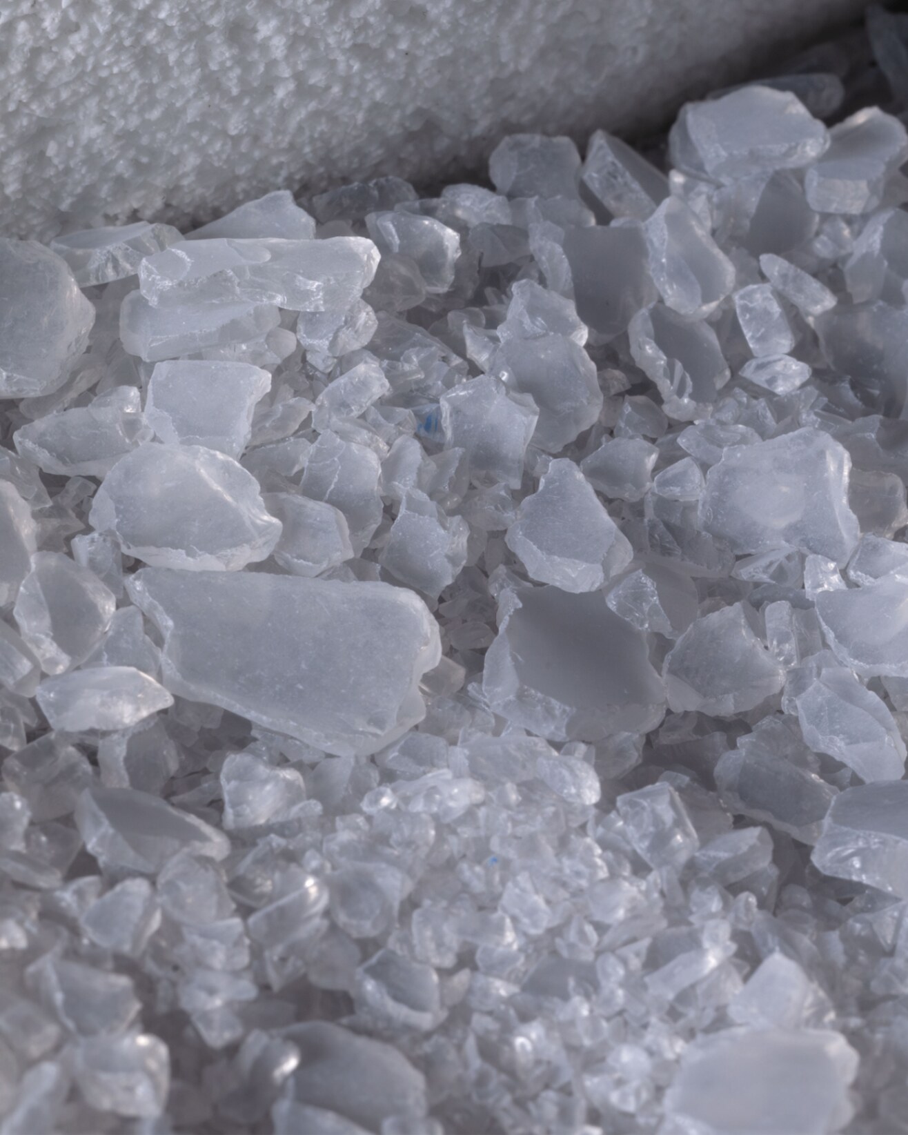 Detail textury materiálu Glassticine — porézní povrch s drobnými skleněnými fragmenty